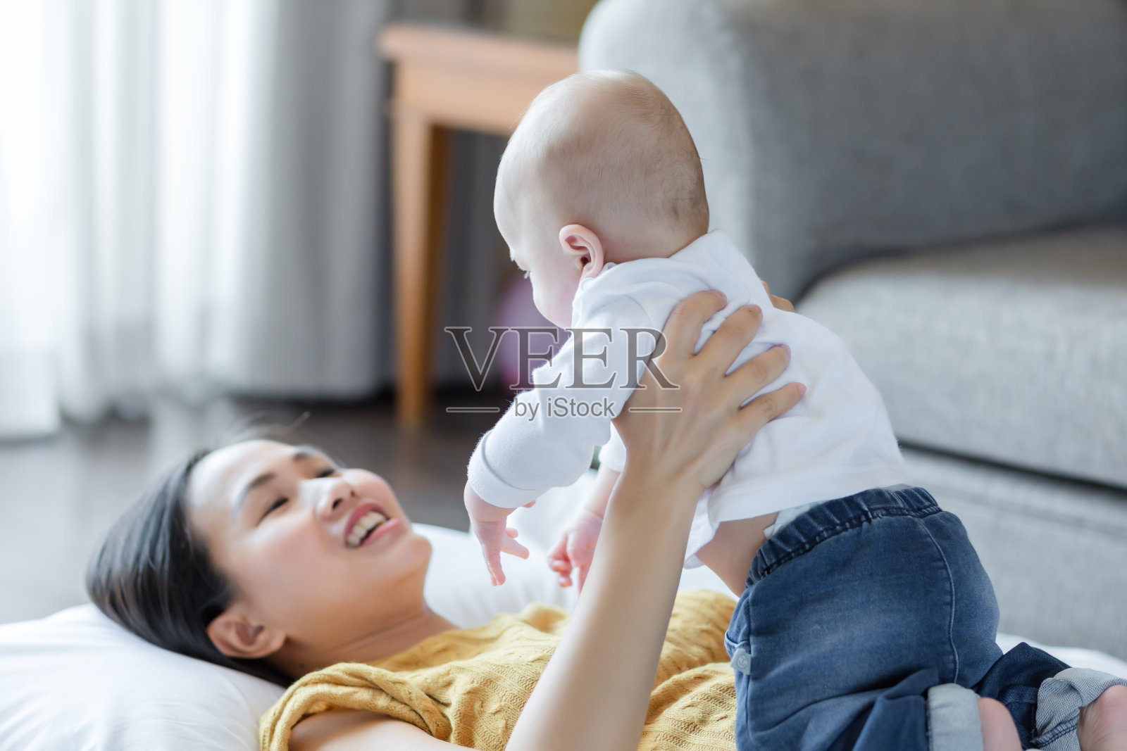 幸福的妈妈和宝宝在家里的床上一起玩耍,家庭爱概念照片摄影图片
