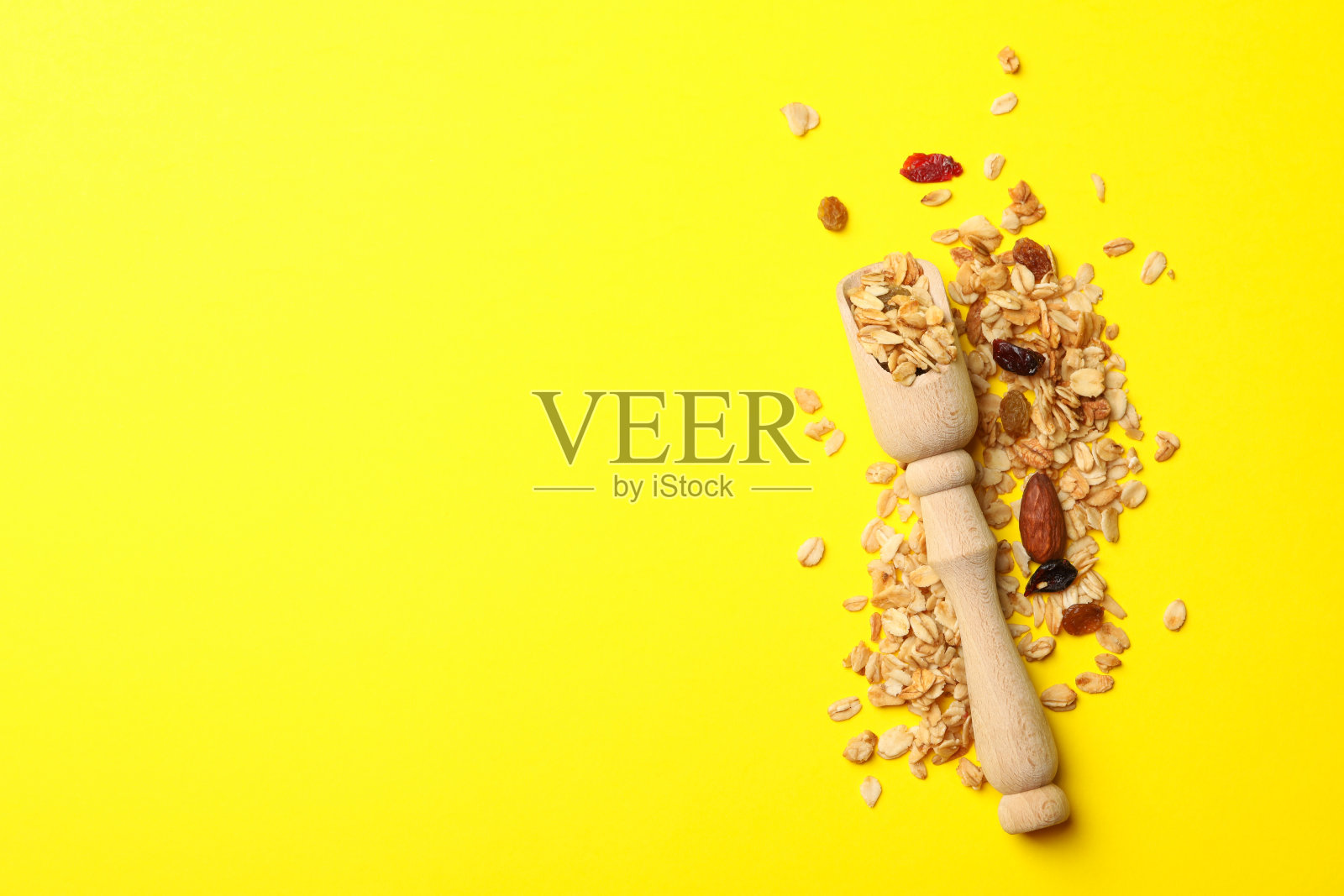 黄色背景上的木勺和麦片照片摄影图片
