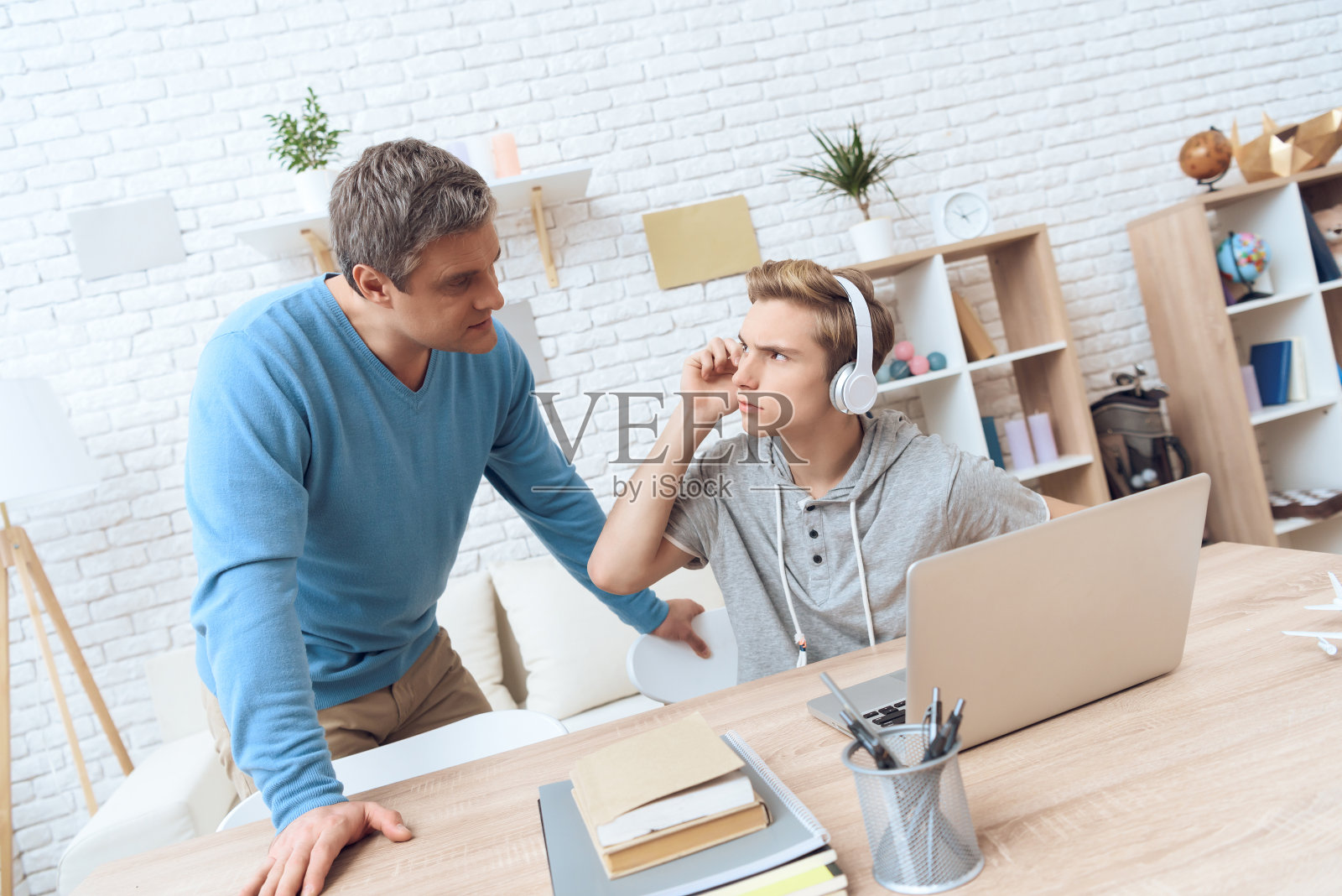 父亲试图让他的儿子远离电脑,但问题少年不愿离开。照片摄影图片