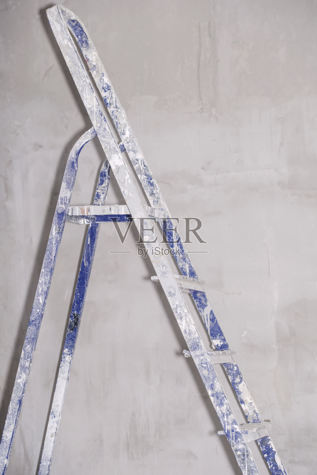 单铝折叠金属踏步梯倚在白色石膏墙的背景照片摄影图片