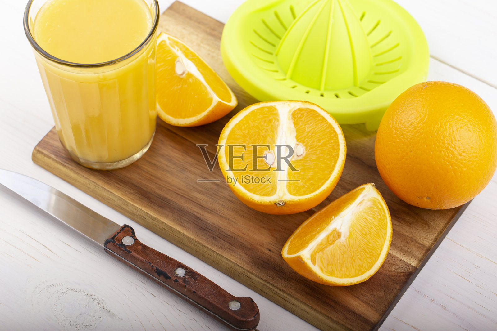 白桌子上放着新鲜的橙汁。照片摄影图片