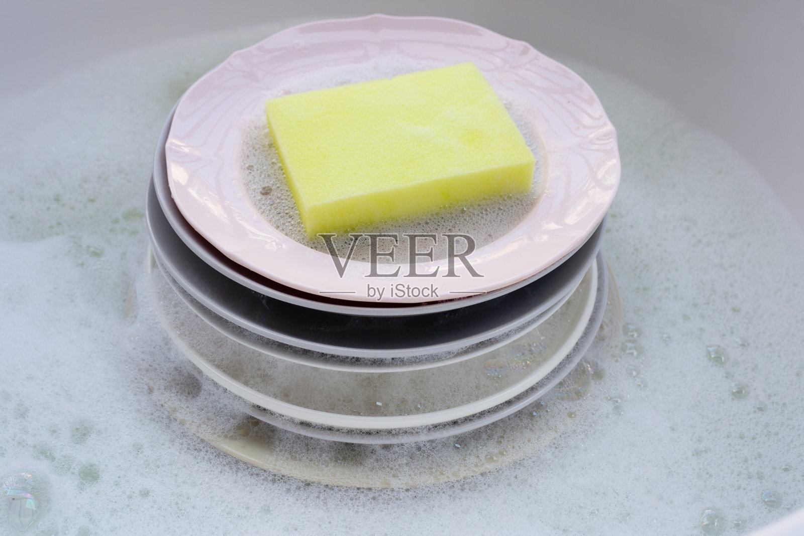 洗盘子,靠近浸泡在厨房水槽中的器具。照片摄影图片