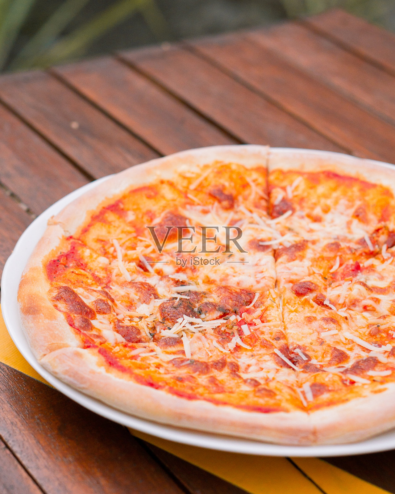 美味的披萨装在盘子里放在木桌上照片摄影图片