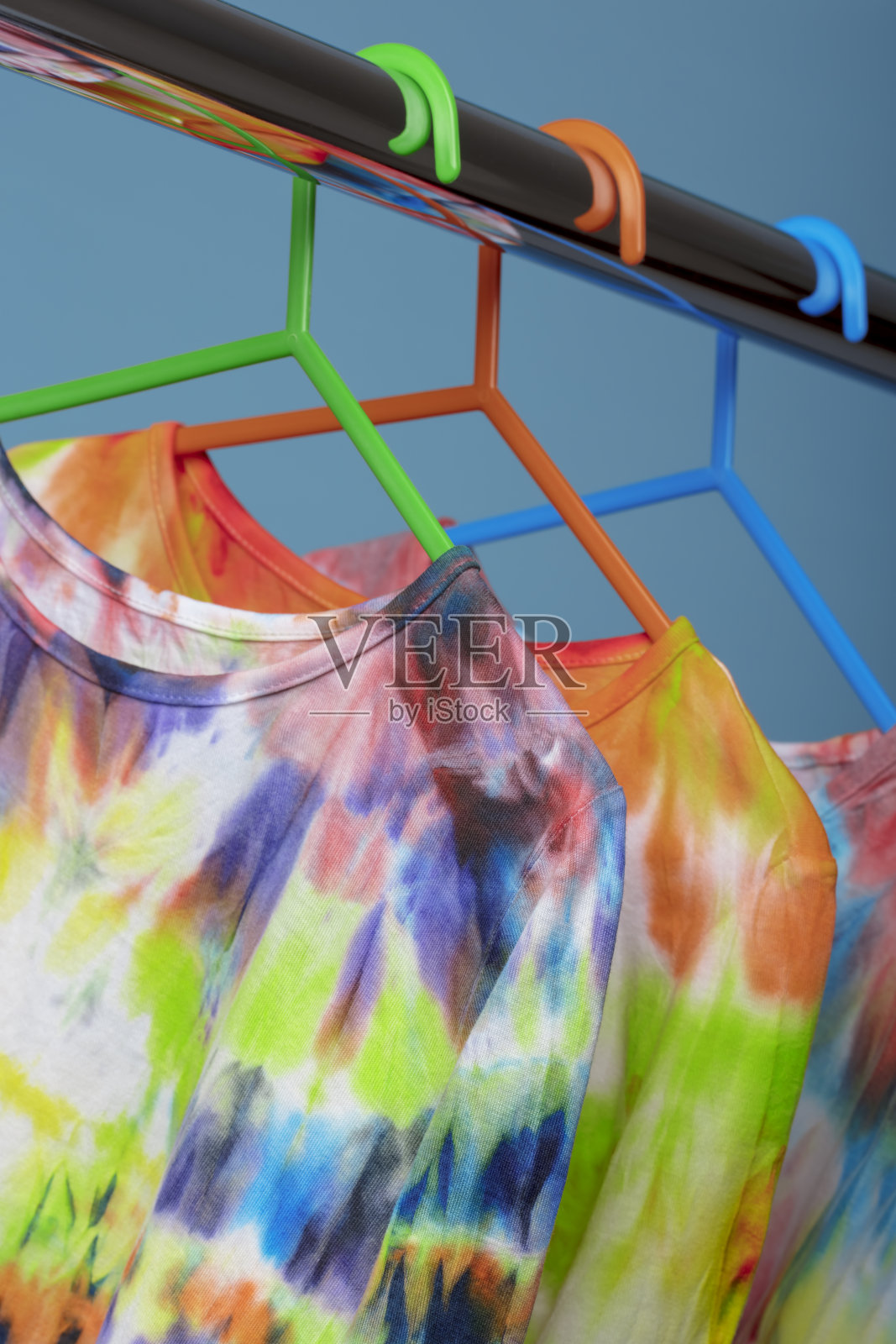 挂在衣架上的彩色扎染长袖衬衫照片摄影图片