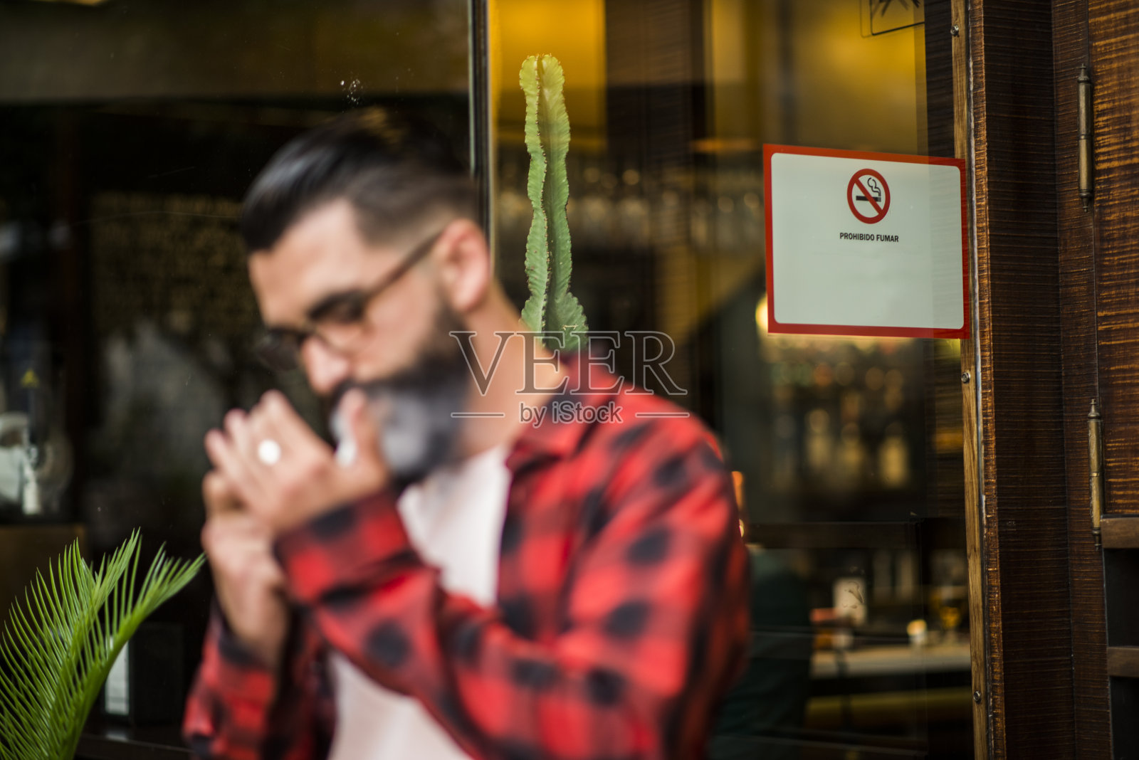模糊的潮人附近的街道上不吸烟的广告,是禁止在室内照片摄影图片