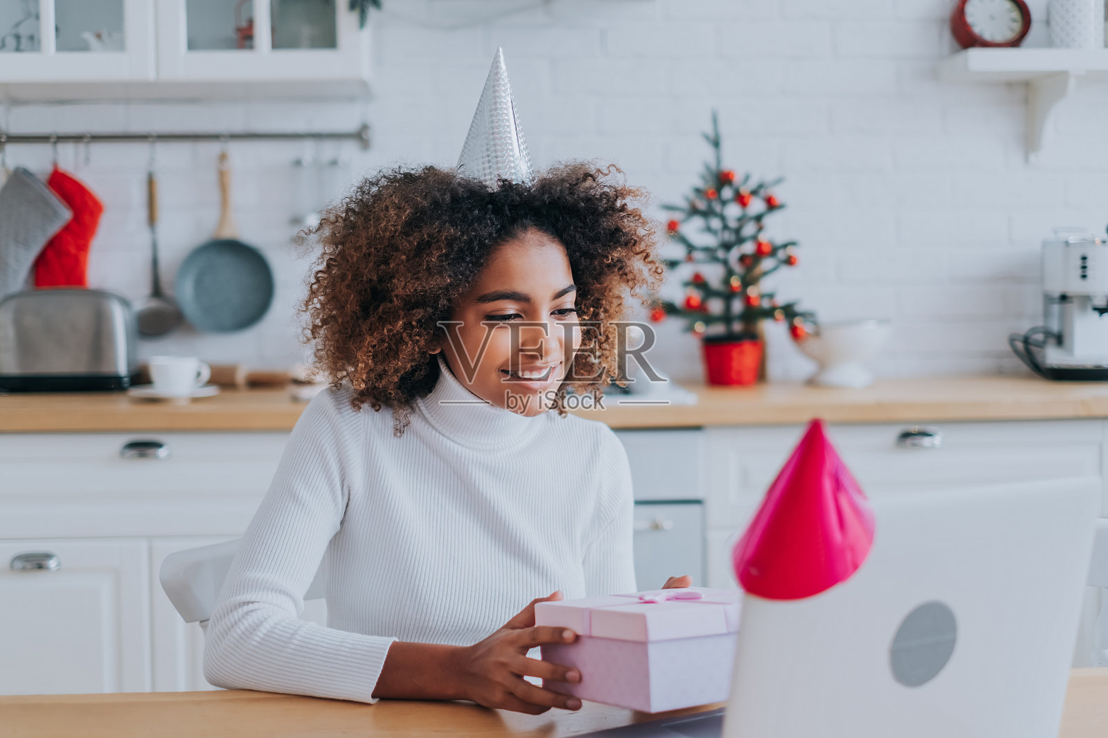 微笑的非洲人拿着装饰好的礼物盒靠近笔记本照片摄影图片