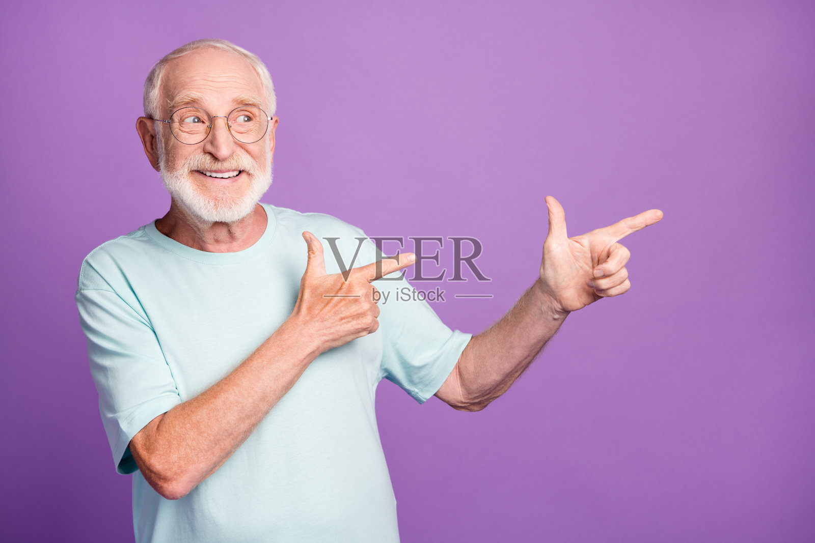 照片肖像的老人指着两个手指的一边孤立在鲜艳的紫色背景照片摄影图片