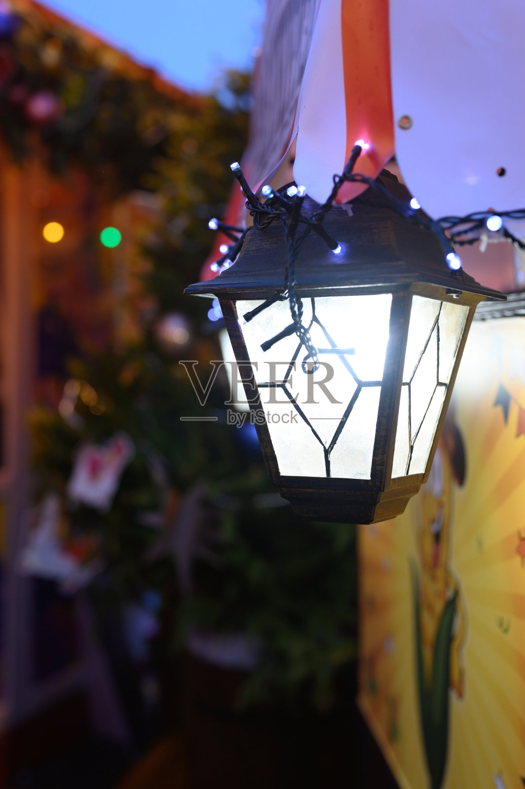 挂着花环的圣诞古董灯笼在新年的夜晚在大街上闪闪发光照片摄影图片