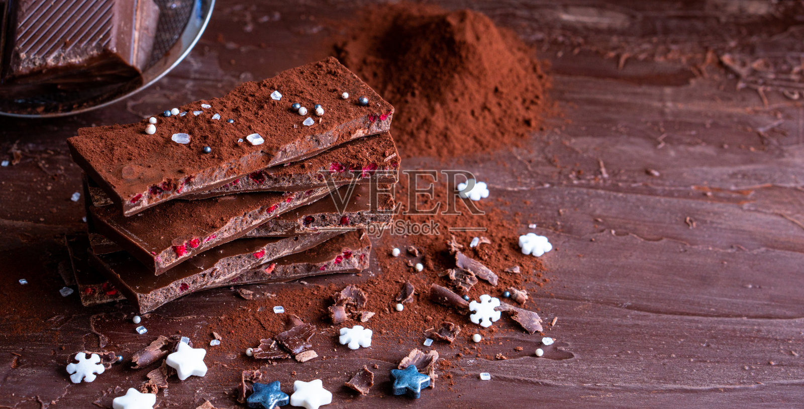 有机食品零食,美味的甜甜点,牛奶,黑巧克力棒,大近景,破碎的幻灯片片,水果,橘子,树莓,榛子,坚果,可可粉,木桌子作为新年圣诞礼物照片摄影图片
