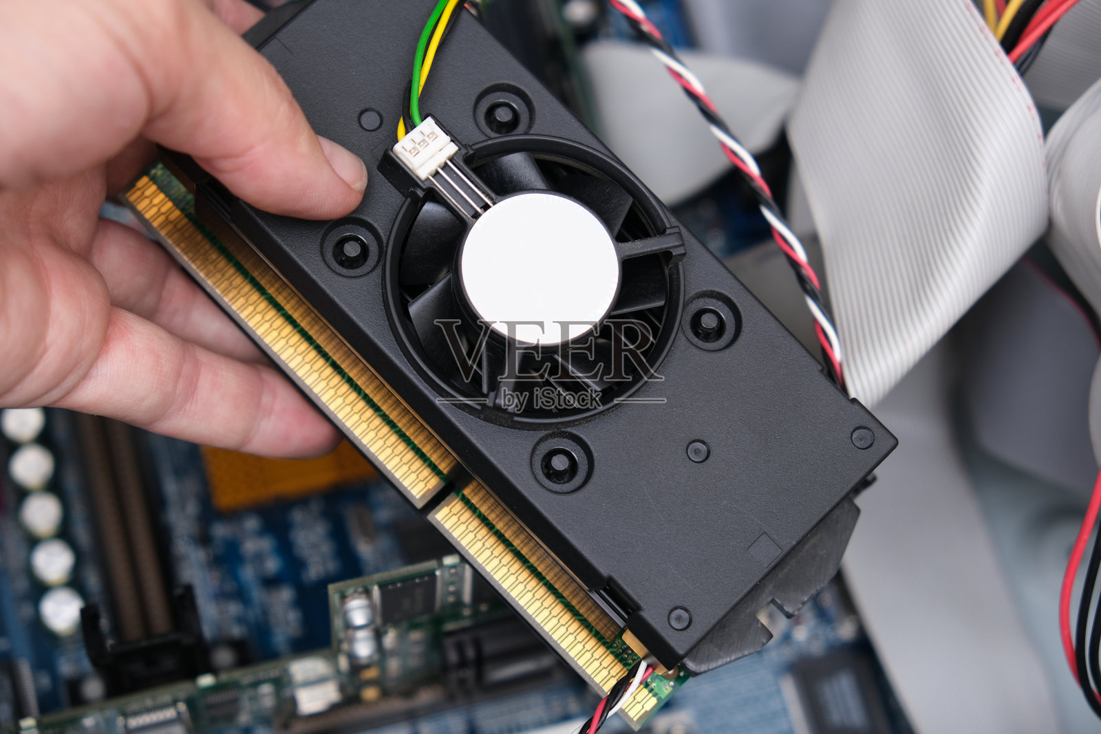 技工的手,修理工人拿着需要更换或升级的电脑的一部分照片摄影图片