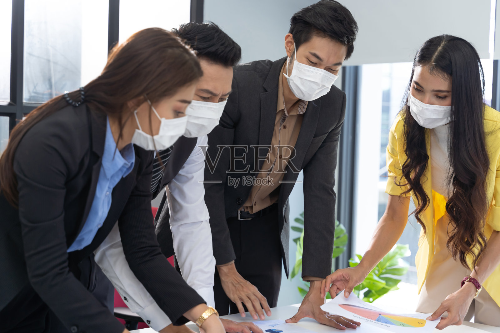 亚洲商务人士小组在办公室开会和工作,佩戴口罩,防止感染冠状病毒covid - 19。照片摄影图片