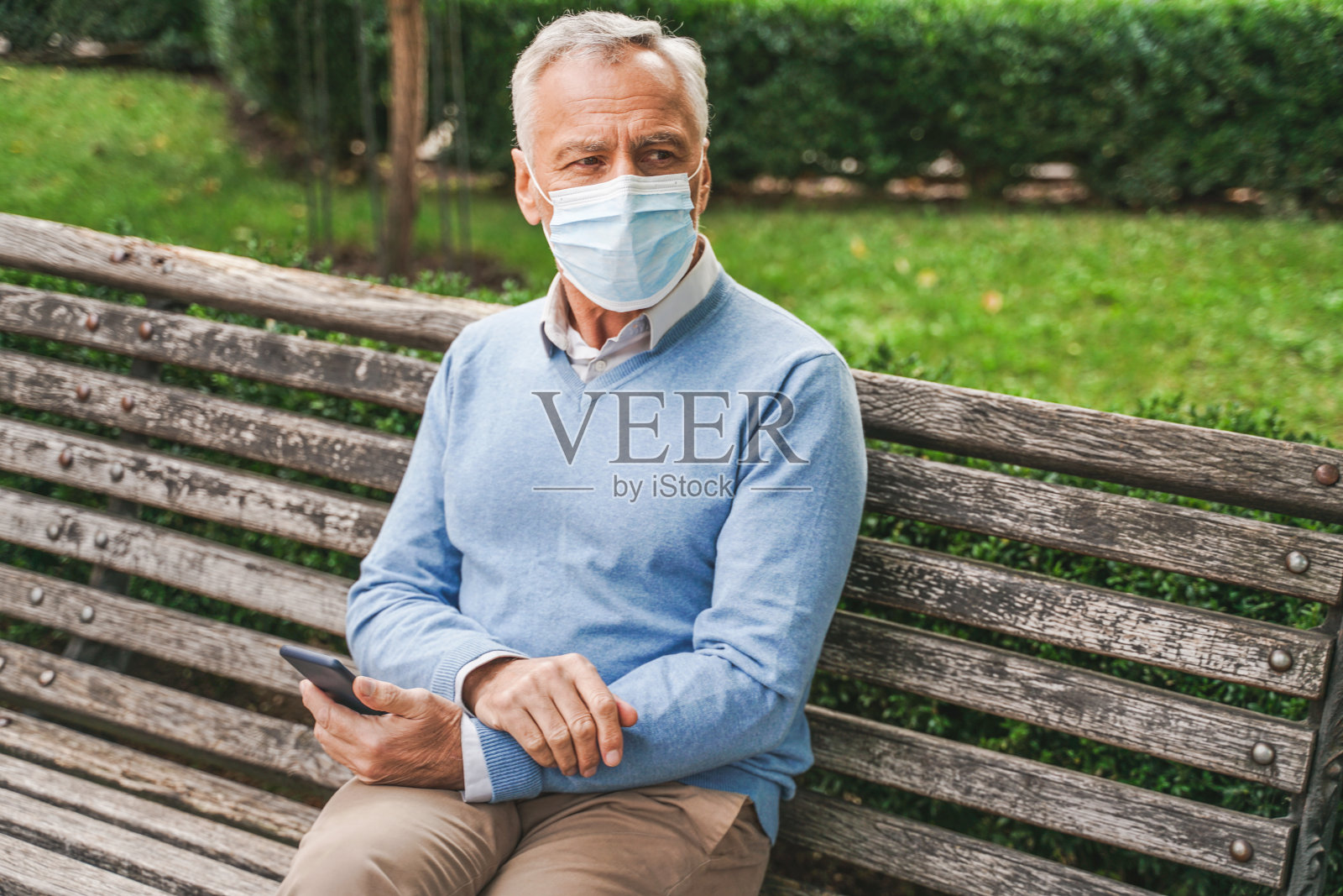 大流行隔离期间,戴口罩的老人在公园内照片摄影图片