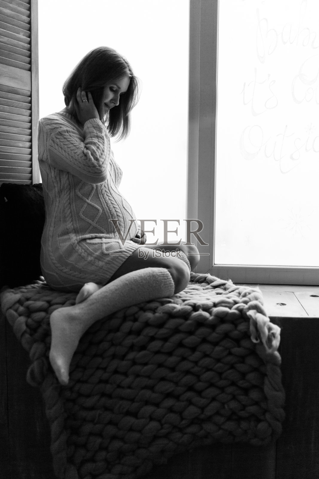 年轻漂亮的孕妇坐在靠窗的地方照片摄影图片