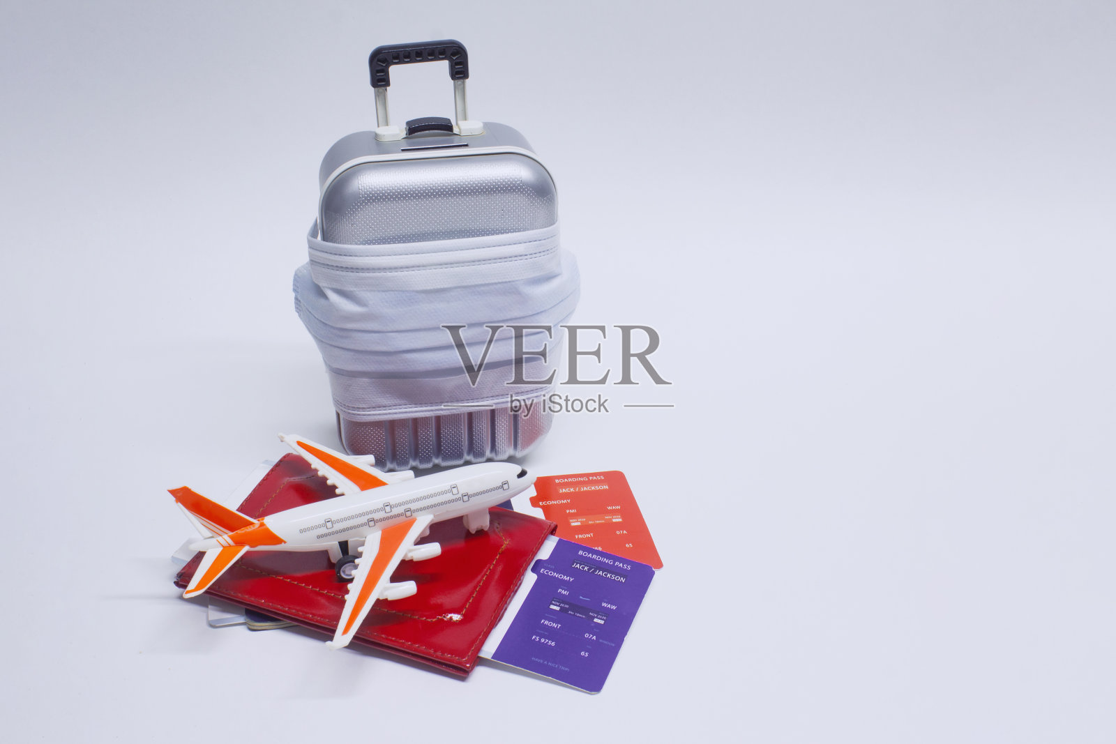 时间旅行。Covid-19冠状病毒大流行期间的安全休息概念。带医用口罩的旅行旅行箱和带飞机的机票。照片摄影图片