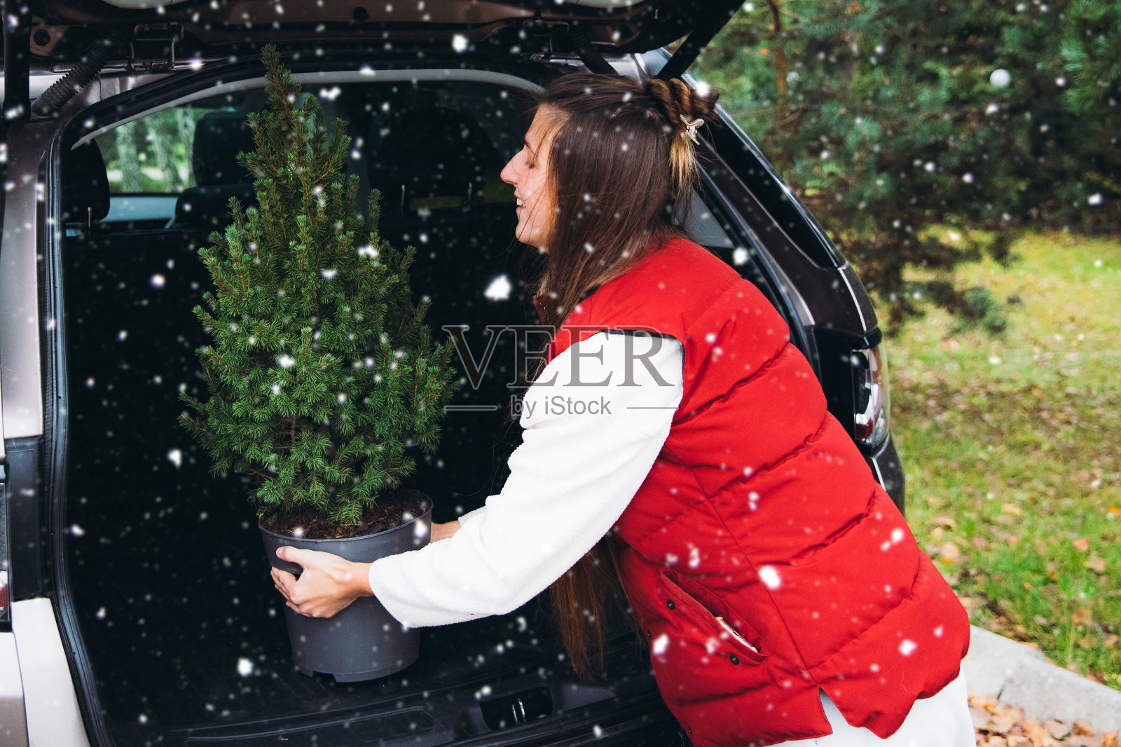 年轻微笑的女人在第一场雪期间为圣诞节做准备照片摄影图片