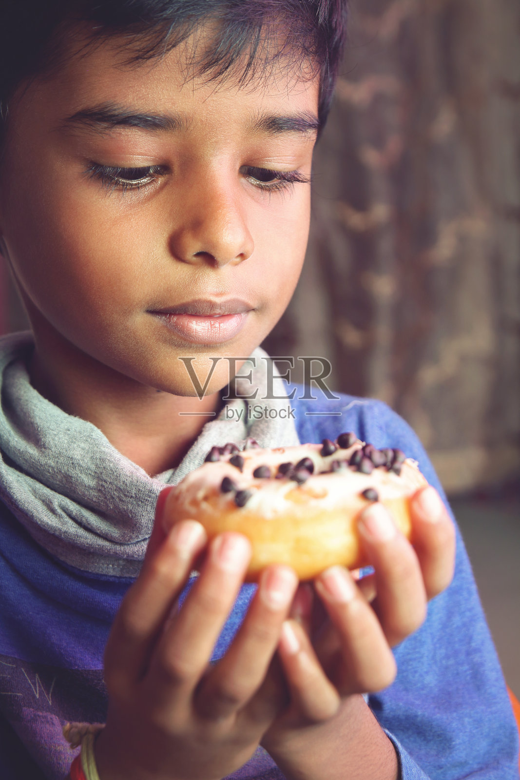 这是一个小男孩在吃甜甜圈照片摄影图片