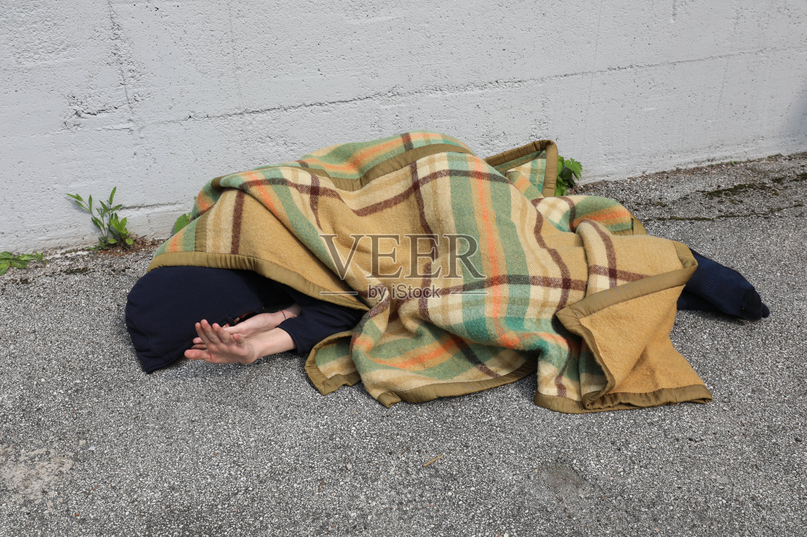 无家可归,他睡在地板上盖着毯子照片摄影图片