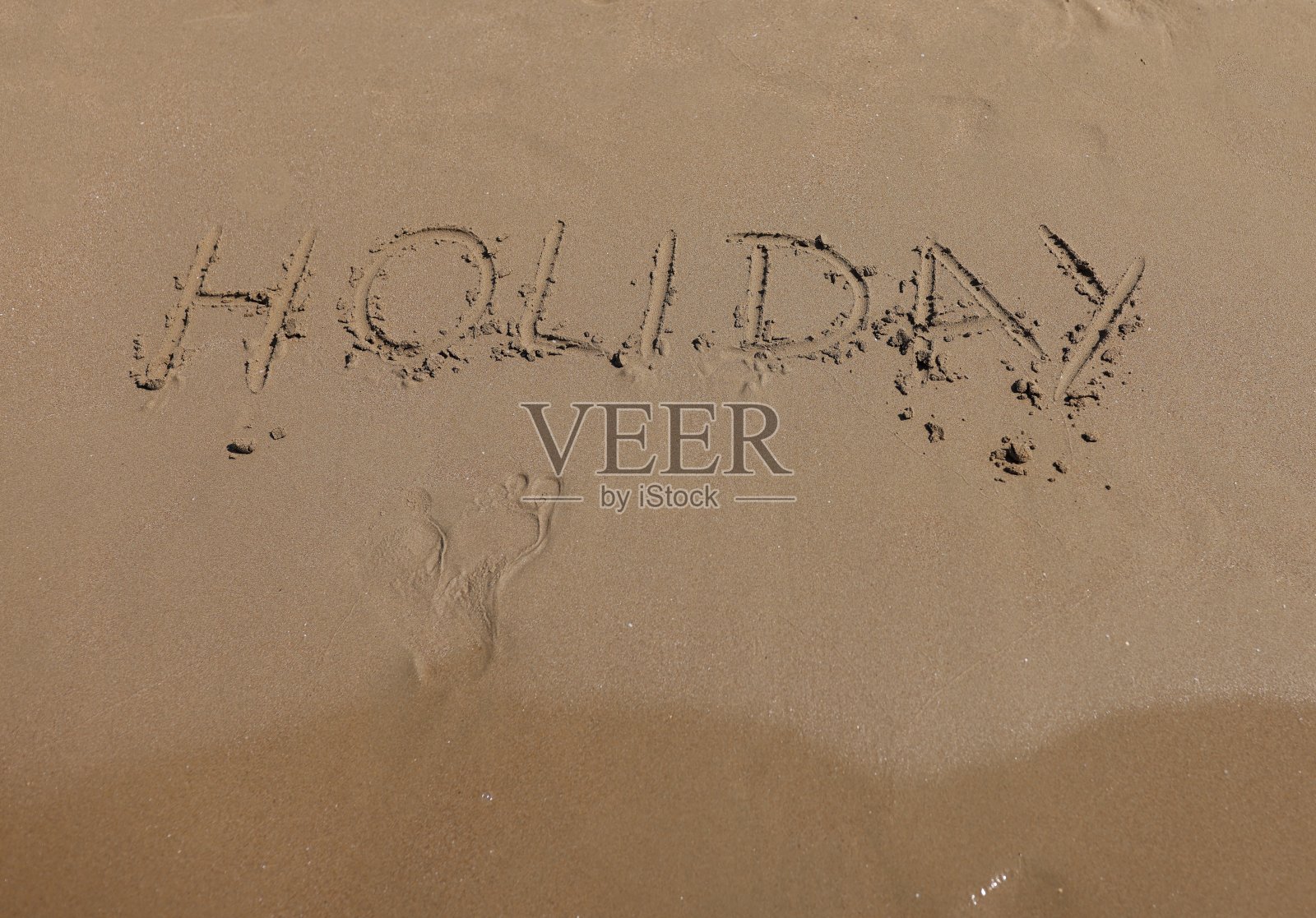 文字和脚印写在沙滩上。照片摄影图片