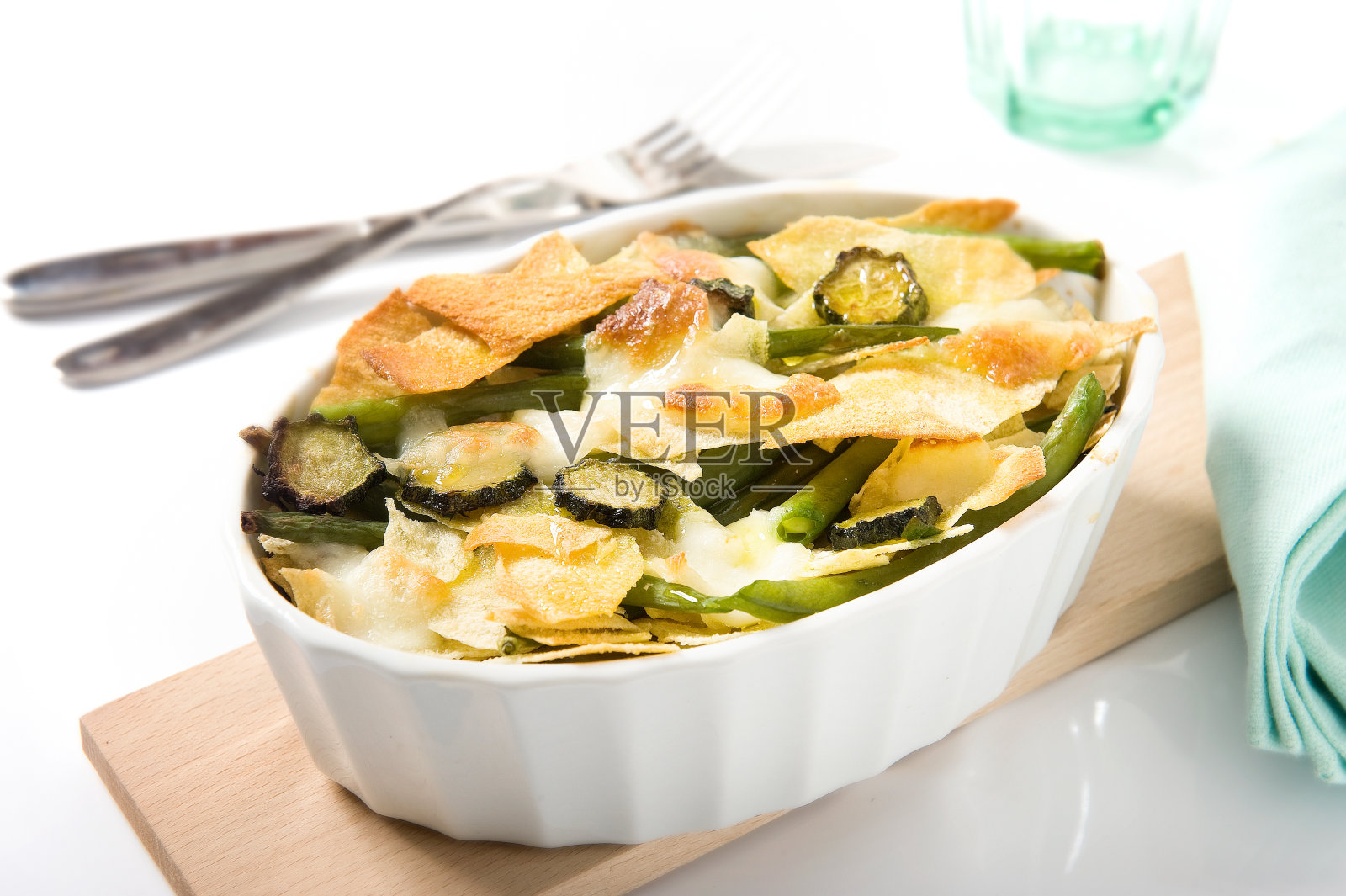 素布丁,西葫芦,青豆,硬皮面包,泡芙和马苏里拉奶酪在白色的桌子上照片摄影图片