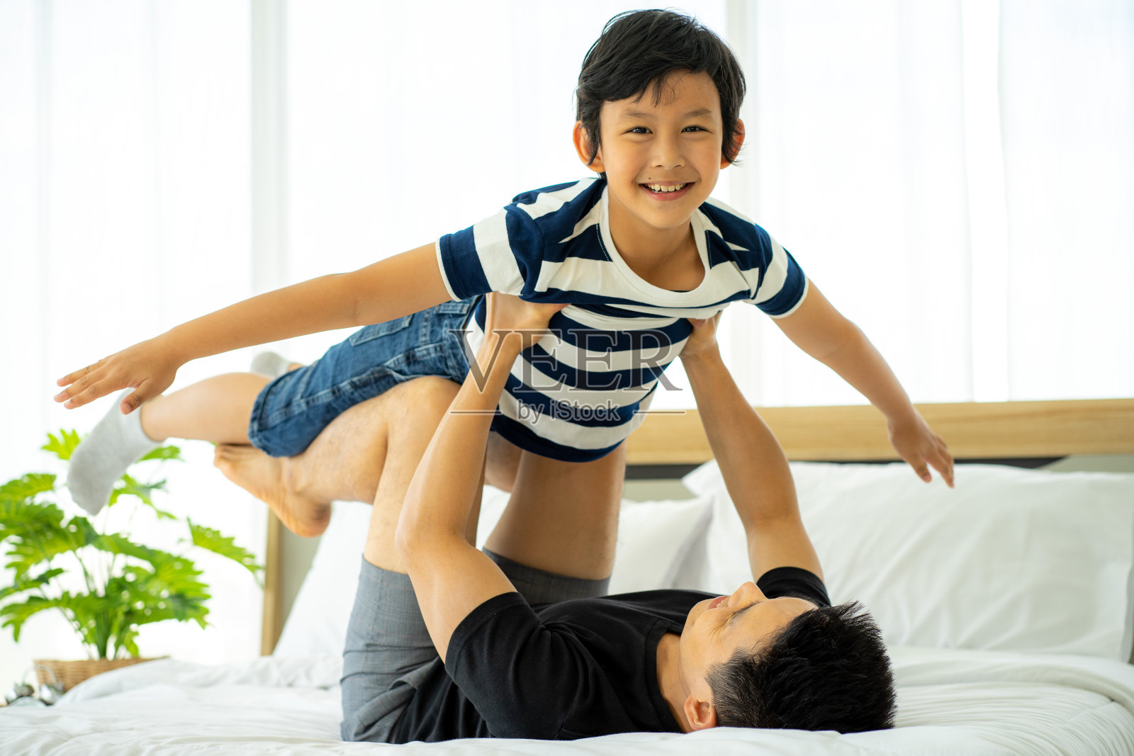 亚洲父亲在家工作,在家里与儿子照片摄影图片