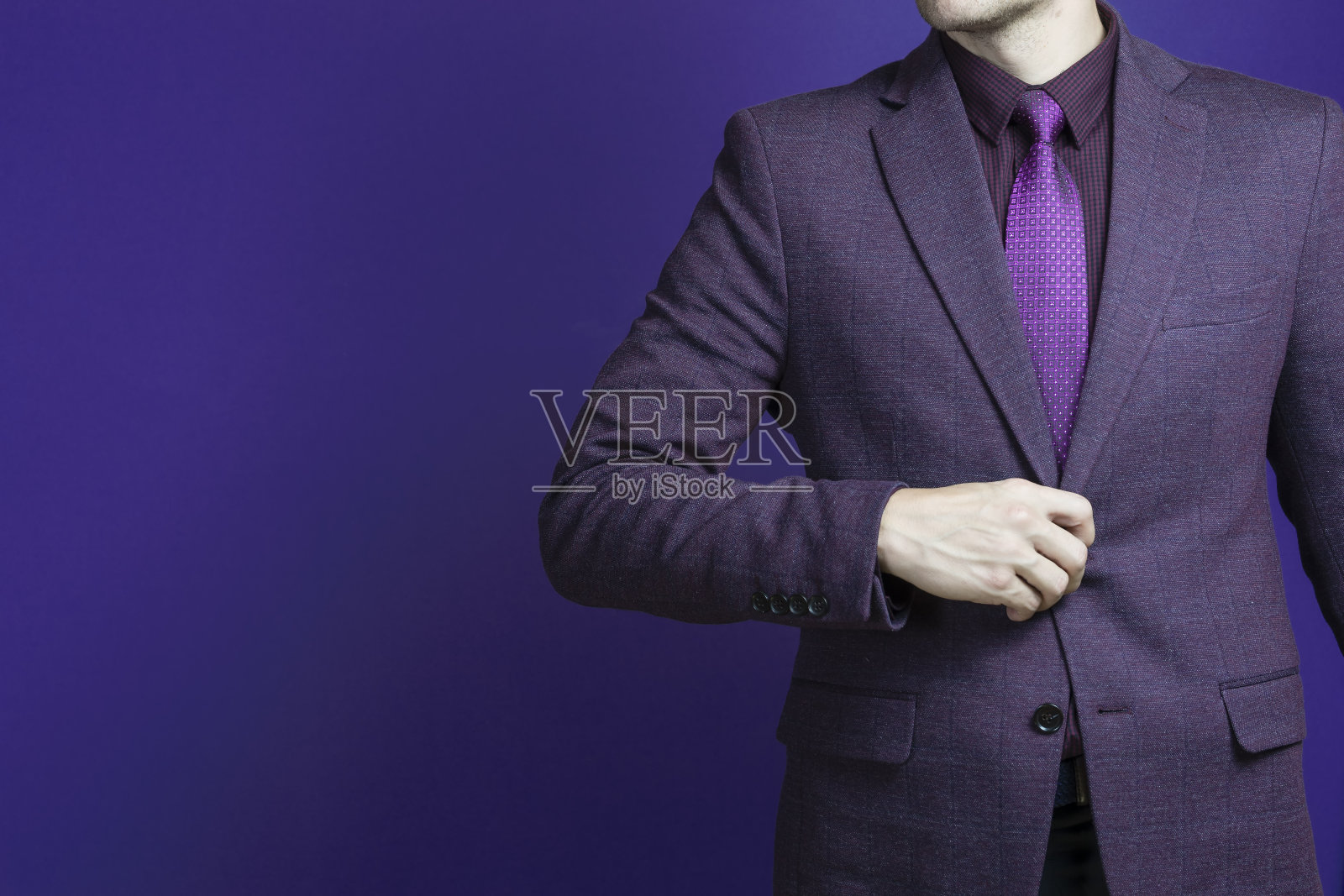 一个商人的特写,在一个紫色的西装自信地在深蓝色的背景。照片摄影图片