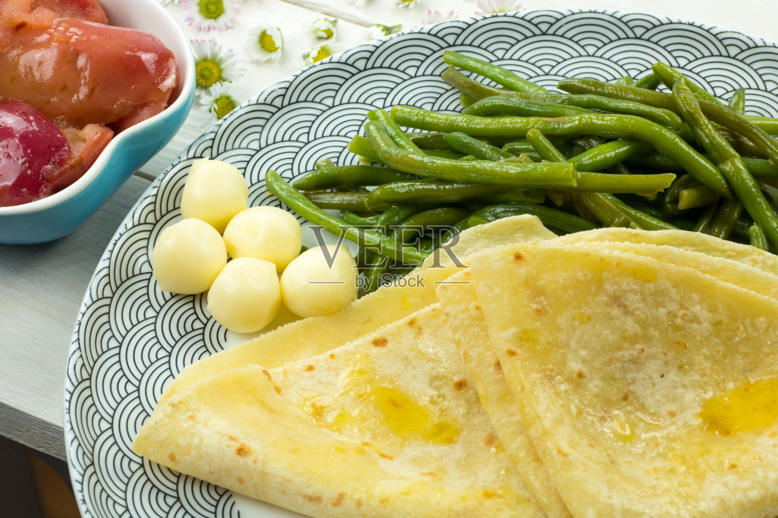 来自斯洛伐克的传统食物。用土豆粉面团做成的咸薄饼。涂上融化的黄油。配绿豆荚,奶酪和焦糖的甜苹果。照片摄影图片