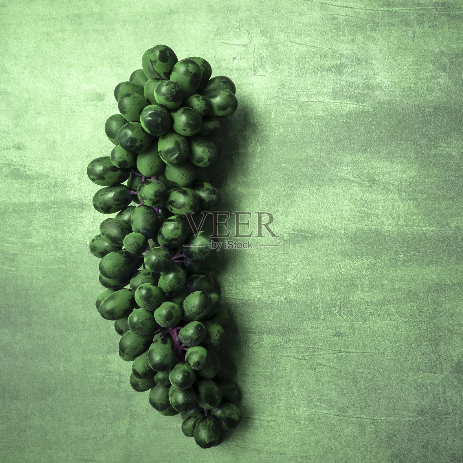 一串多汁的黑葡萄在灰色的背景,从顶部看,自由的文字空间。照片摄影图片