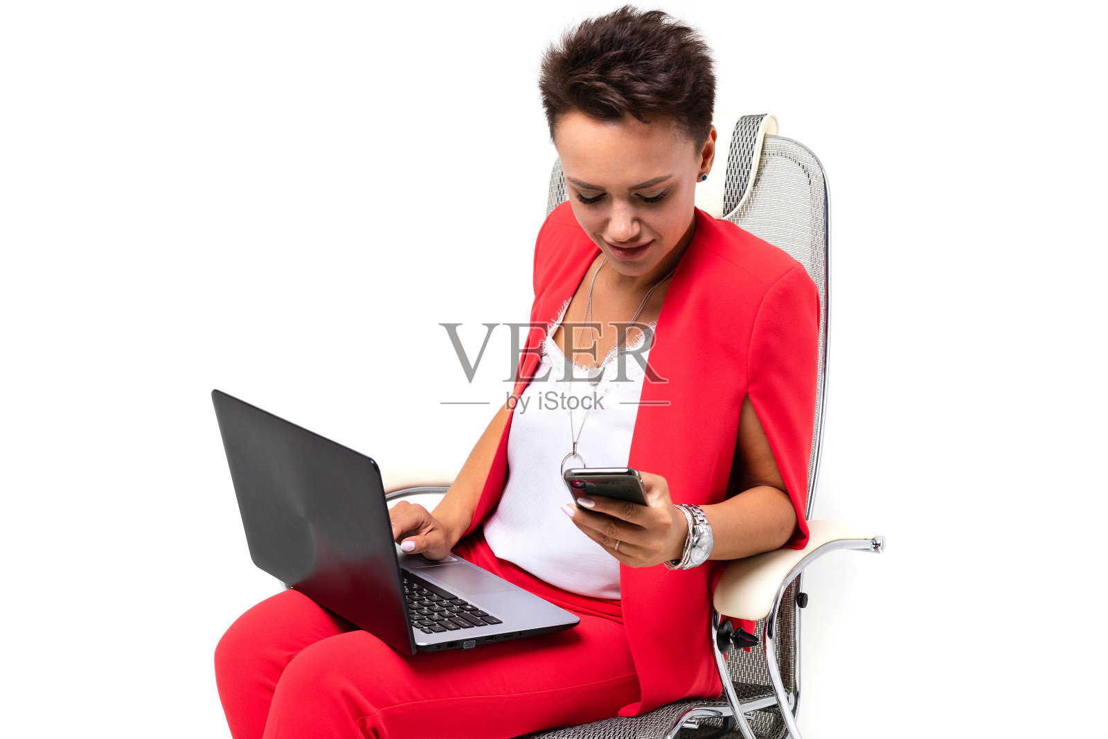 办公室女性坐在椅子上,用电话和笔记本电脑解决问题照片摄影图片