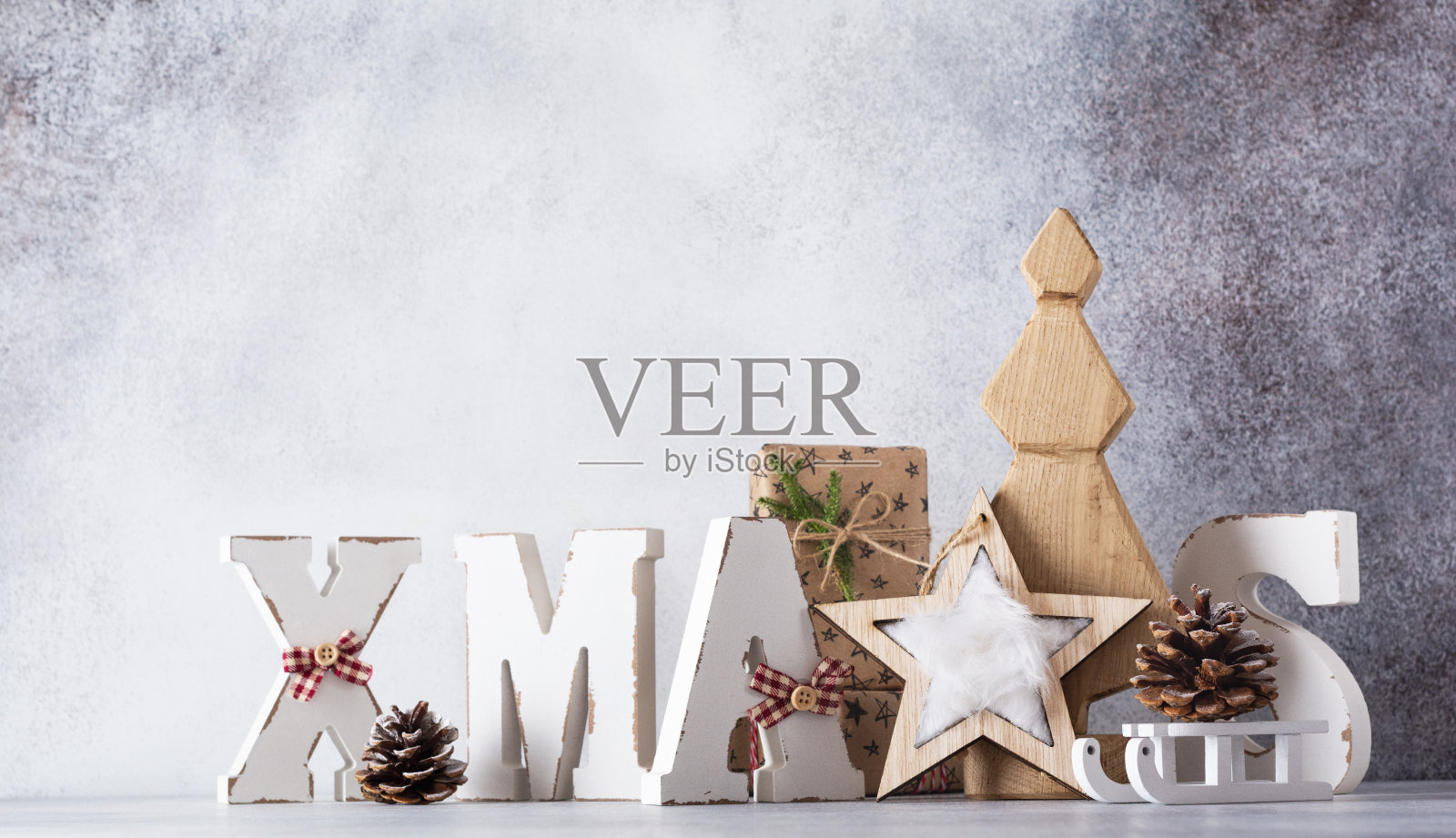 木制字母圣诞和装饰圣诞树,星星,锥形,礼品盒在浅灰色的背景。零浪费圣诞理念。照片摄影图片