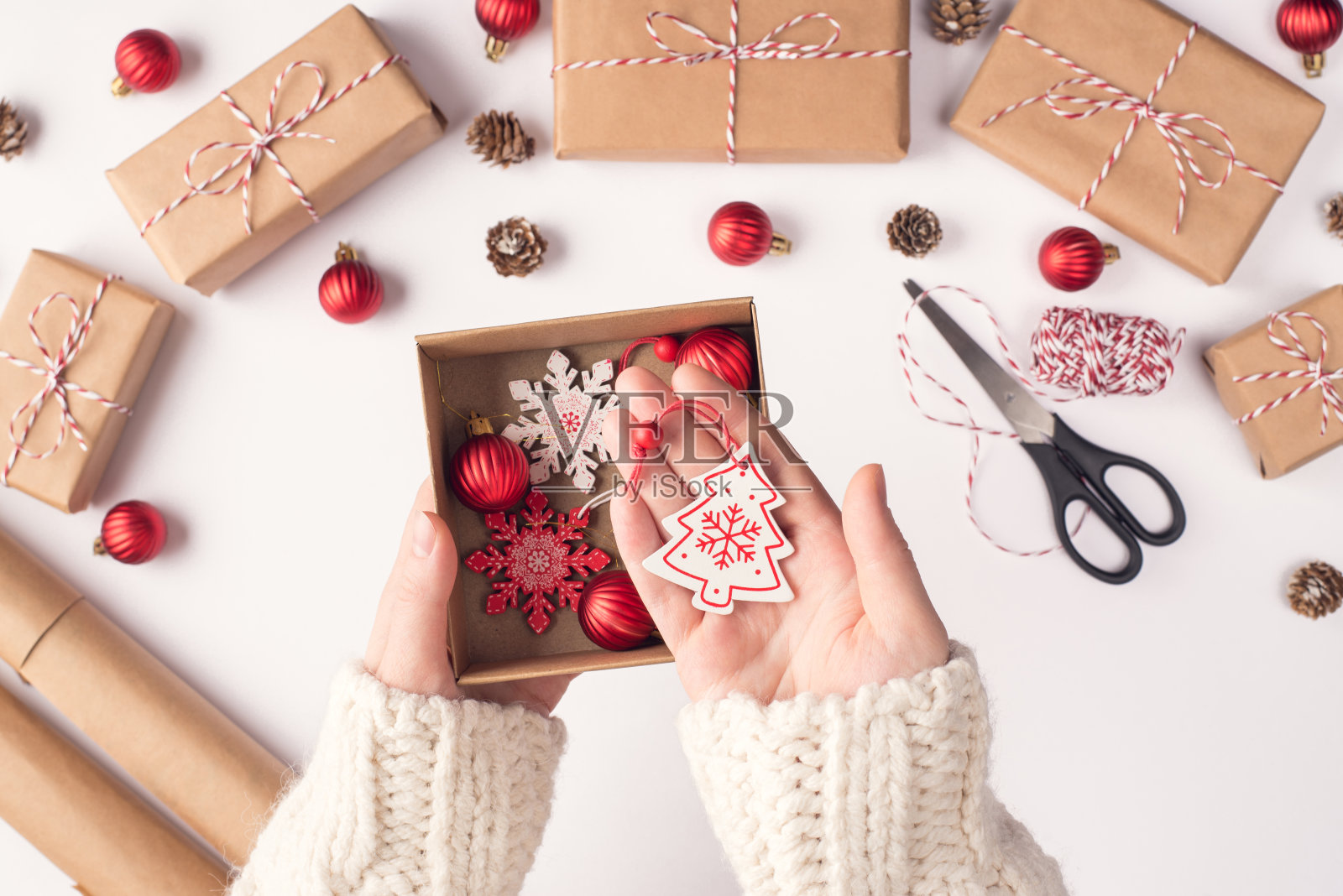 Pov顶部以上近距离俯瞰照片的女性手握展示盒与圣诞节装饰展示挂树雪花在白色的工作场所照片摄影图片