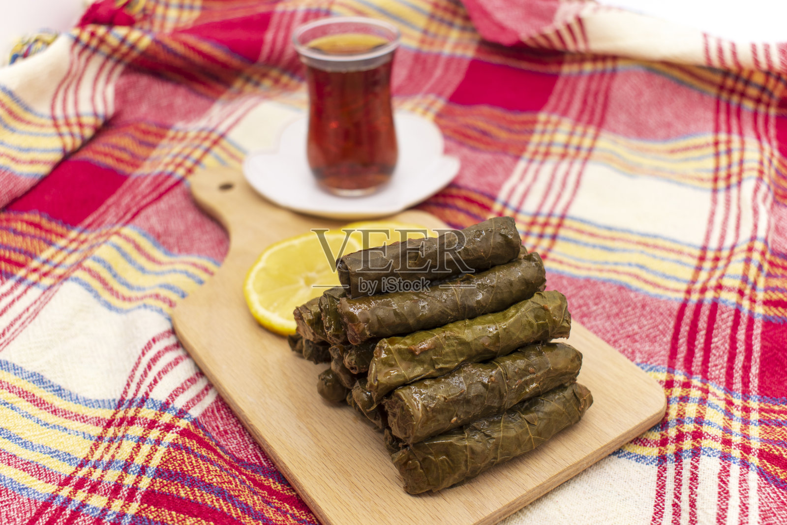 萨尔马是一种土耳其传统著名的葡萄叶子食物。土耳其食物;(yaprak sarma dolma)传统的用叶子包裹的米饭,配茶和柠檬照片摄影图片