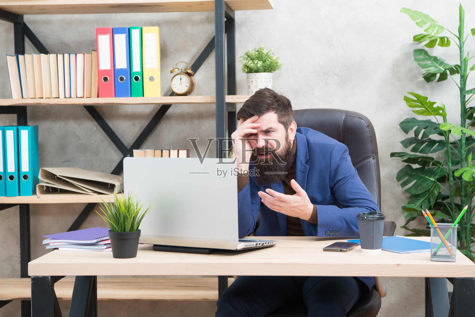 工作压力大,穿着正装的商人。压力大的男人使用笔记本电脑。老板在工作场所工作。压力大的大胡子男人在商务办公室工作。工作后感到压力。真的忙照片摄影图片