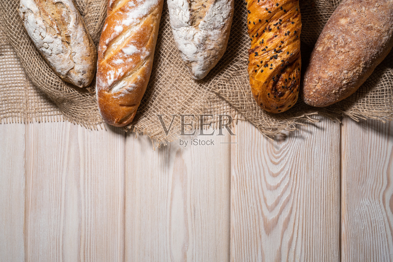 不同种类的面包放在木头背景上照片摄影图片