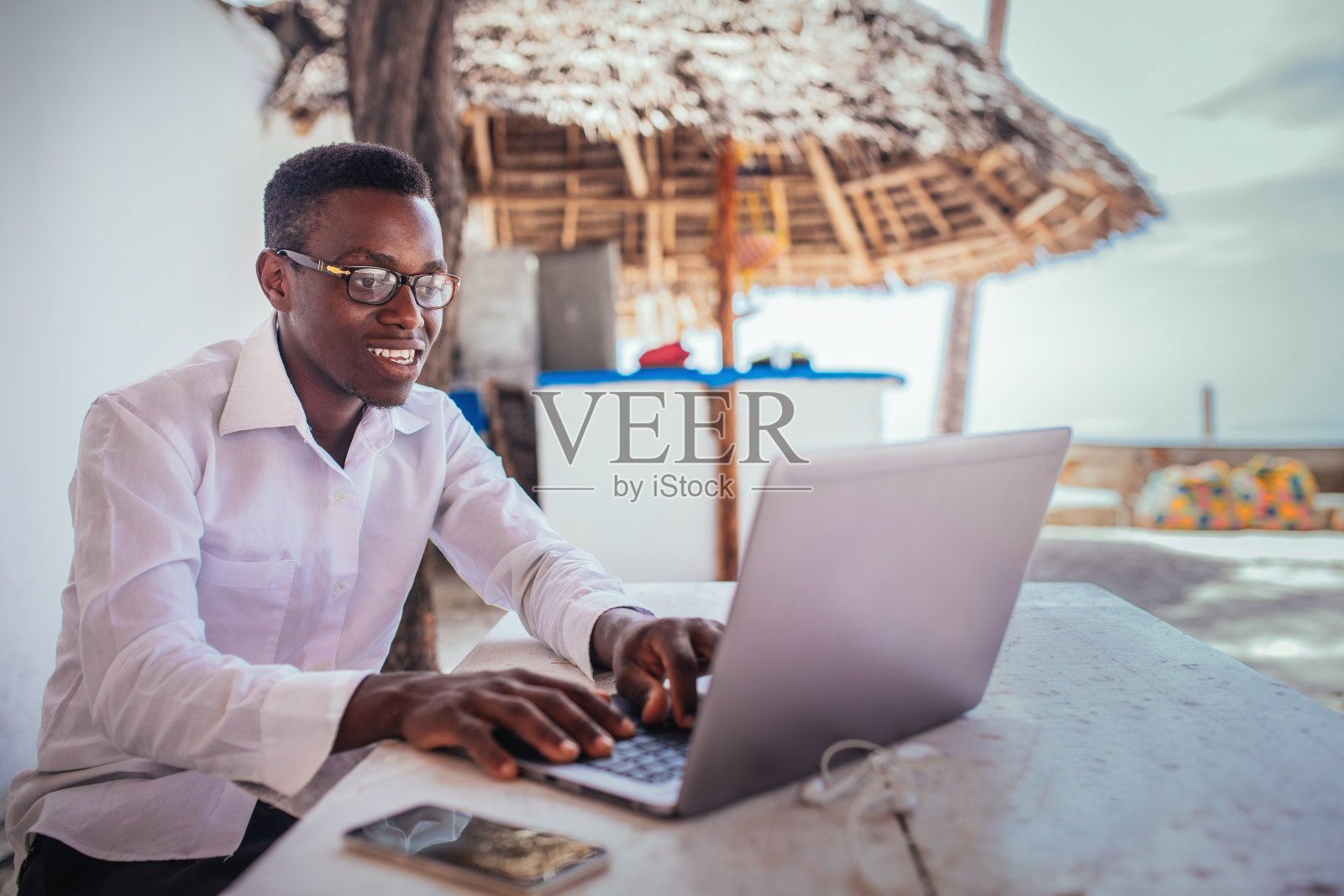 年轻的学生在海滩上使用笔记本电脑照片摄影图片