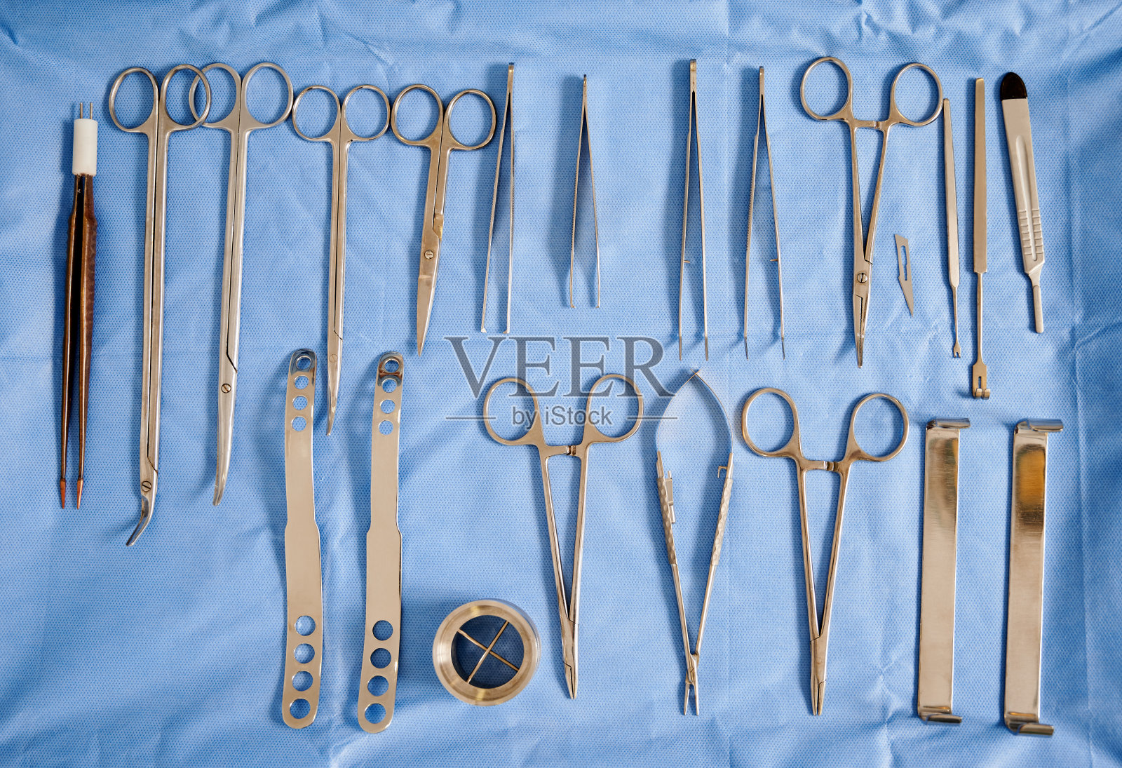 蓝色医用布上的整形手术器械。照片摄影图片
