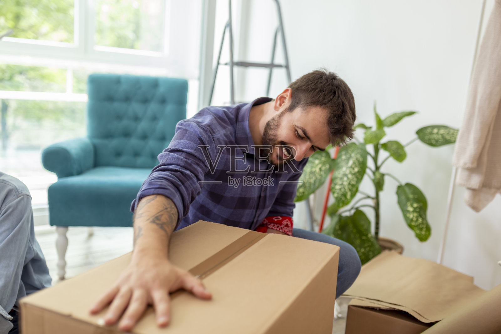 搬运工使用包装机,在搬家时捆扎箱子照片摄影图片