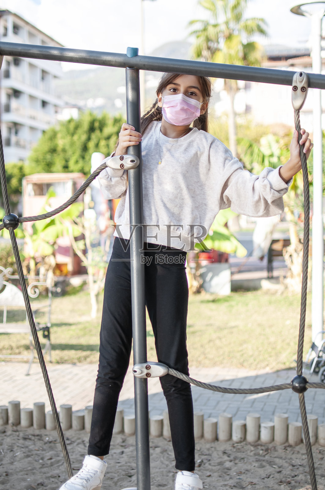 可爱的女孩喜欢带着面具滑梯照片摄影图片