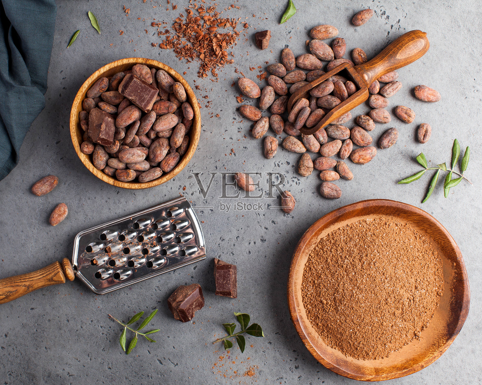 在灰色背景上放置可可豆,可可粉,生巧克力。健康饮食的概念。照片摄影图片