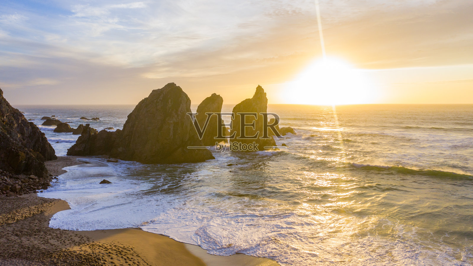 日落时海蚀柱的海滩鸟瞰图照片摄影图片