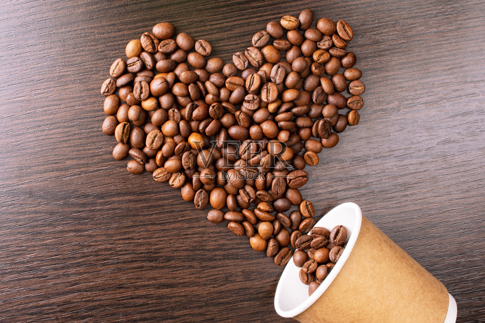 用咖啡豆做成的心形。烘培咖啡豆背景近景。国际咖啡日概念。照片摄影图片