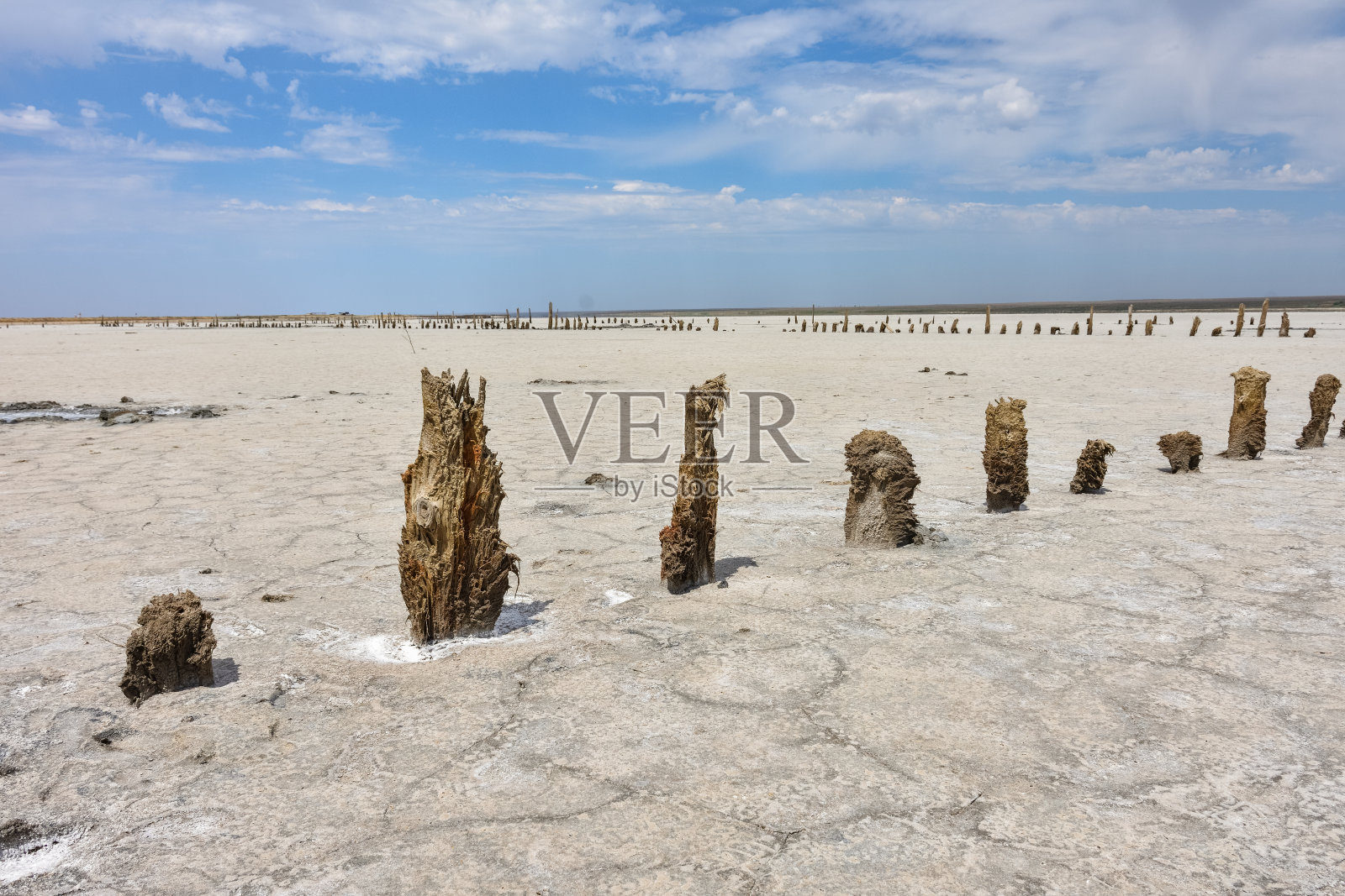 令人惊叹的白色盐沙漠或盐湖。一个盐湖的木制建筑的遗迹。干涸的盐湖,被盐吃掉的房子,腐烂的木头房子照片摄影图片