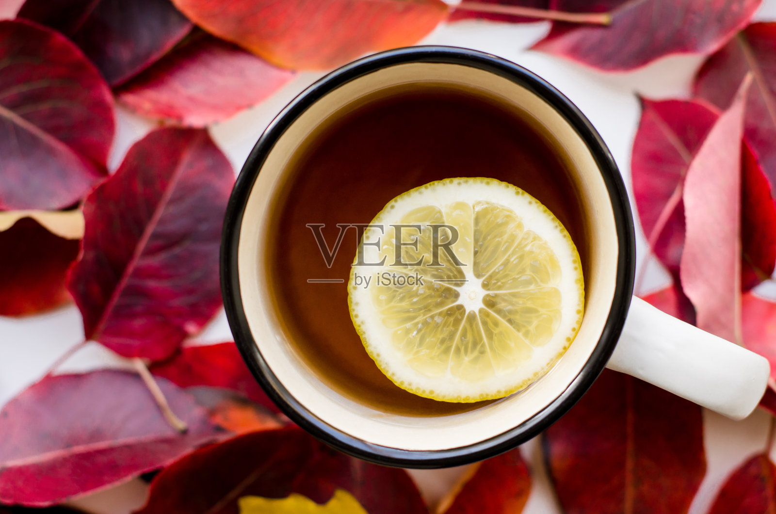 一杯柠檬茶,红色叶子背景特写照片摄影图片