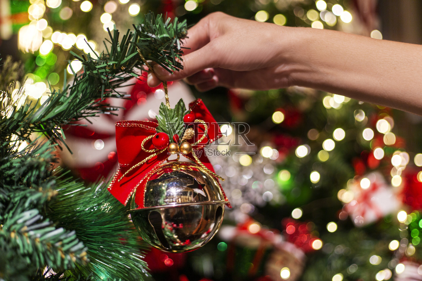 最后一笔,特写的女人装饰圣诞树的圣诞节照片摄影图片