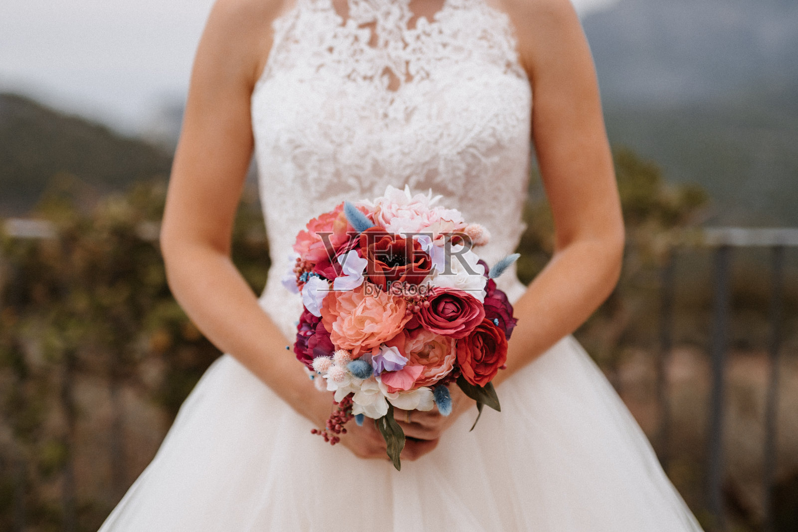 新娘手持白色婚纱的精美婚礼捧花照片摄影图片