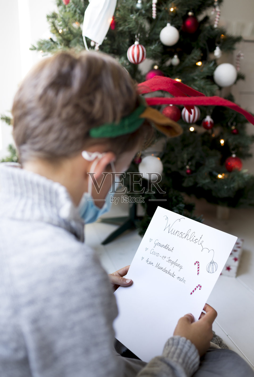 年幼的孩子在corona危机期间写圣诞愿望清单照片摄影图片