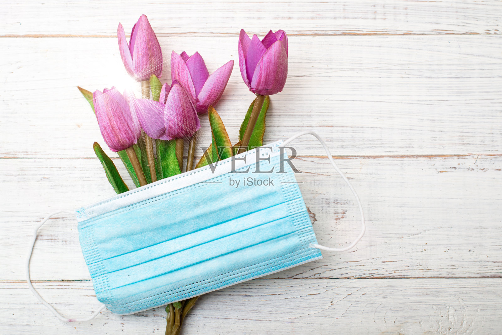 一束花和一个医用面具。冠状病毒的概念。照片摄影图片