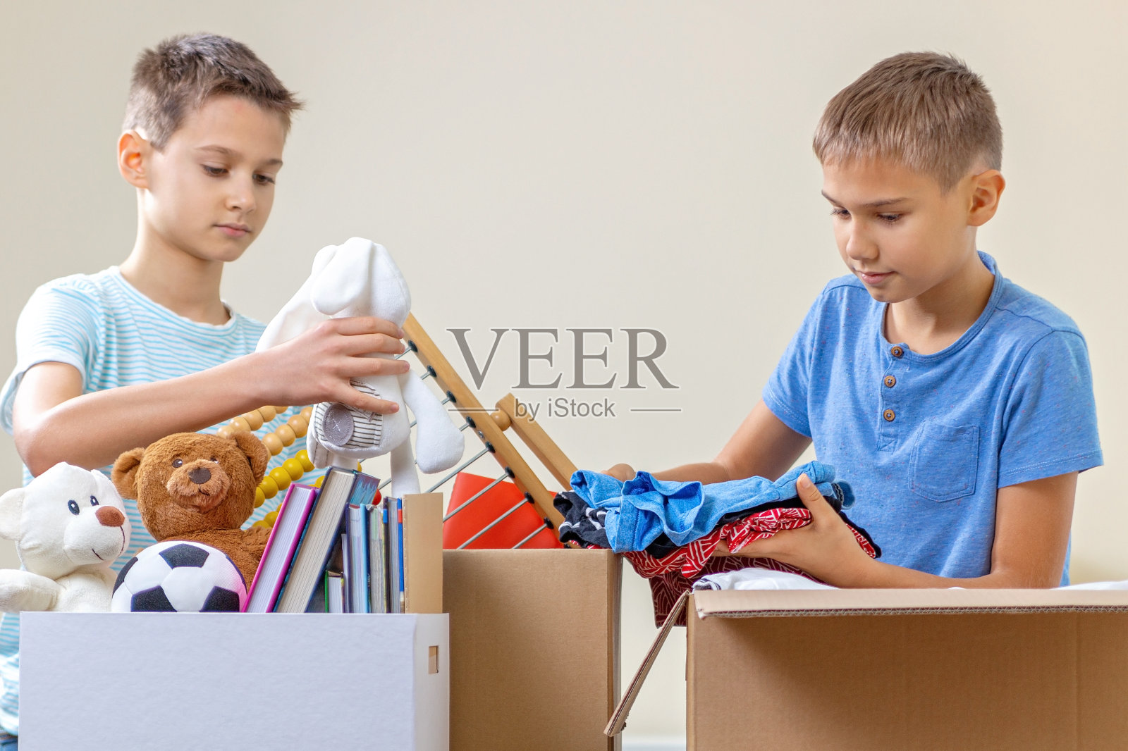 儿童志愿者整理玩具,衣服,书籍,捐赠的物品在捐赠慈善箱照片摄影图片