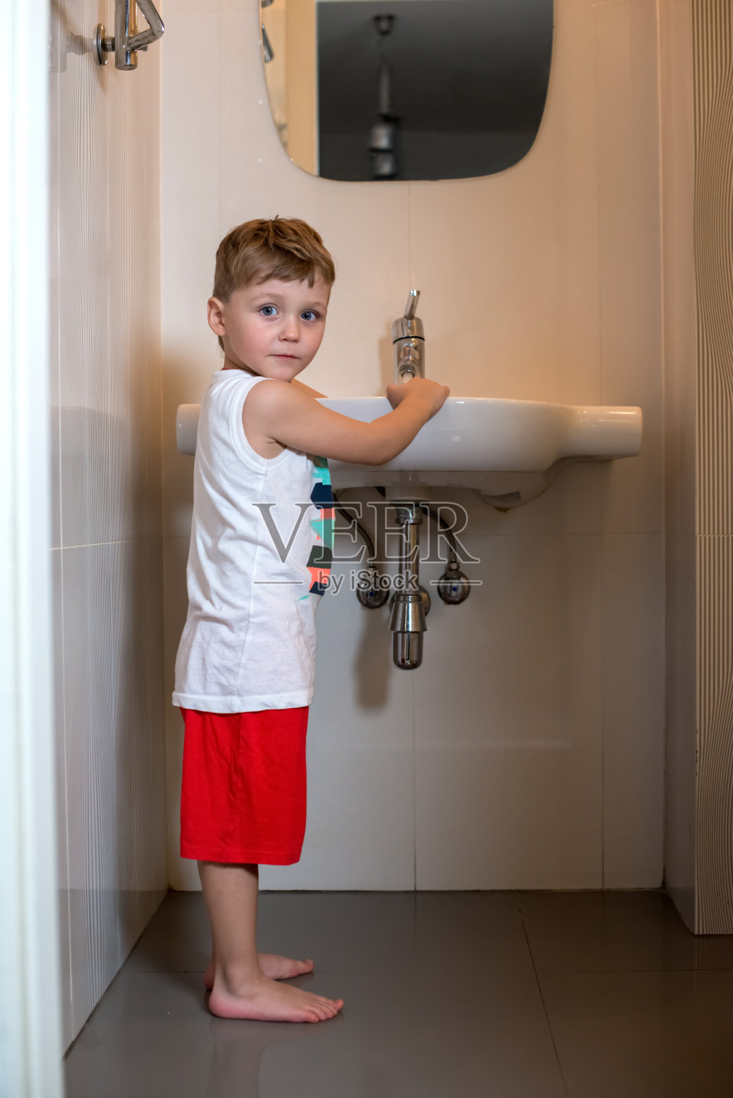 男孩睡觉前在浴室洗手。照片摄影图片