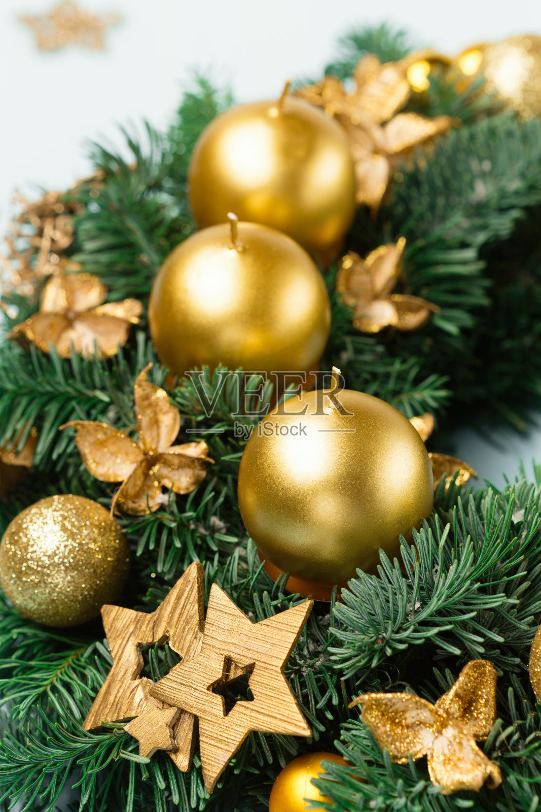 蓝色木质背景上有金色蜡烛的圣诞花环或花冠。照片摄影图片