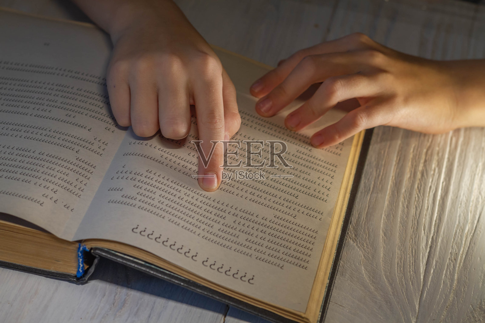 一个人试着去读一本书,但是读不了。这孩子知道字母表中的字母照片摄影图片